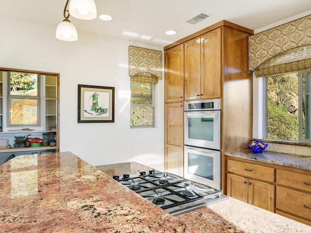 kitchen with light stone counters, visible vents, recessed lighting, stainless steel appliances, and decorative light fixtures