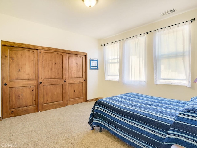 carpeted bedroom featuring visible vents