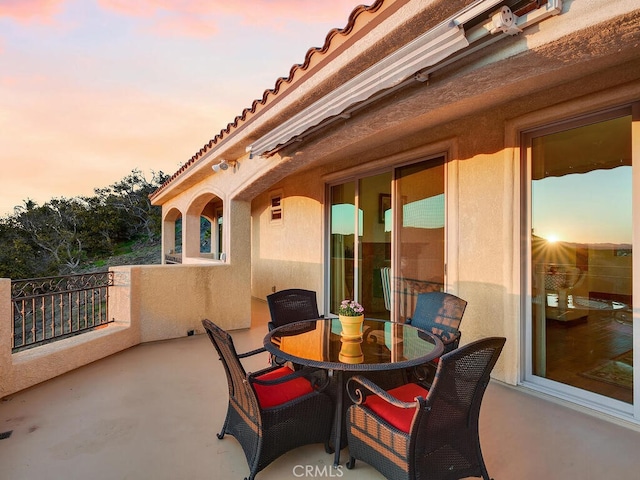 view of patio featuring outdoor dining area and a balcony