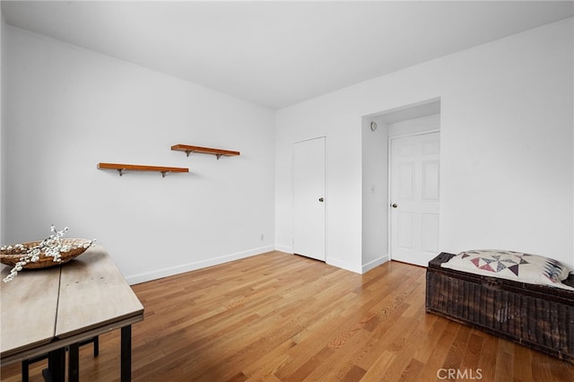 living area featuring baseboards and light wood-type flooring