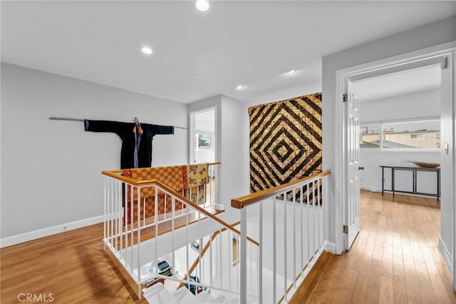 hall featuring an upstairs landing, recessed lighting, baseboards, and hardwood / wood-style floors