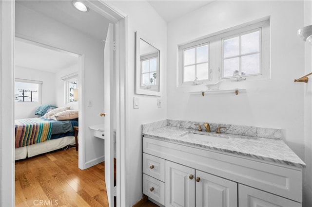 bathroom featuring ensuite bath, vanity, and wood finished floors