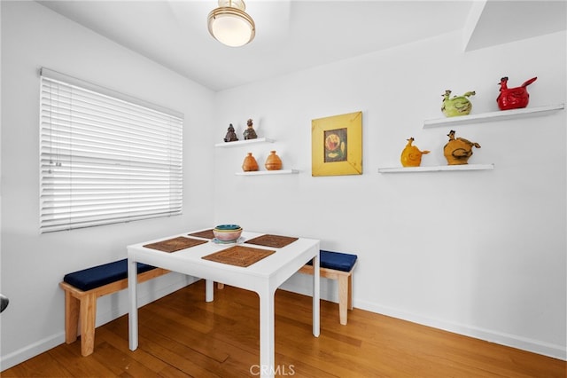 dining space with baseboards and wood finished floors