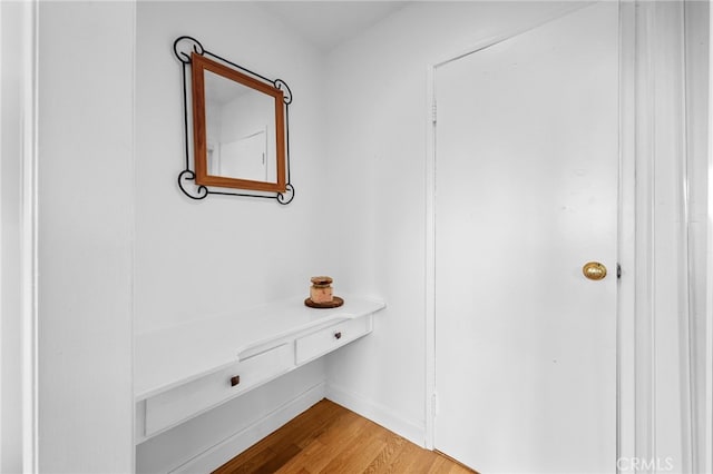 hall featuring baseboards and light wood finished floors