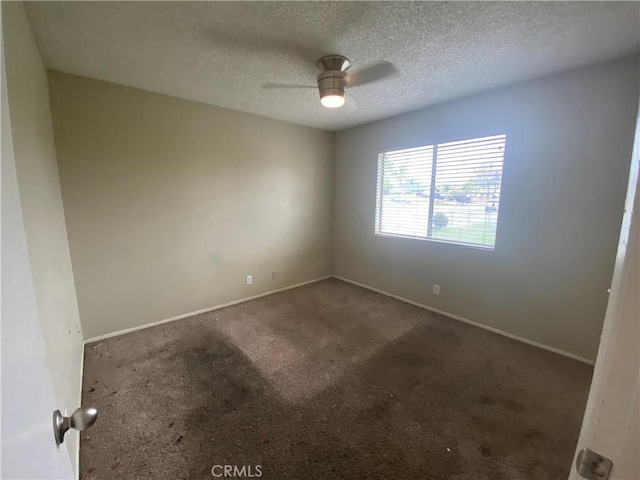 carpeted spare room with baseboards, a textured ceiling, and a ceiling fan