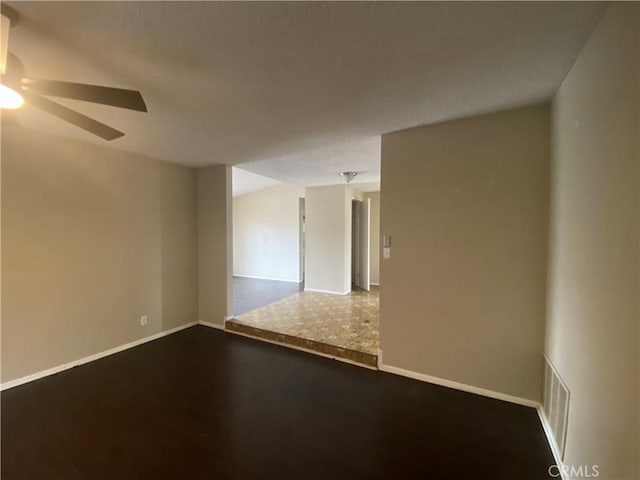 unfurnished room with visible vents, baseboards, a textured ceiling, and a ceiling fan