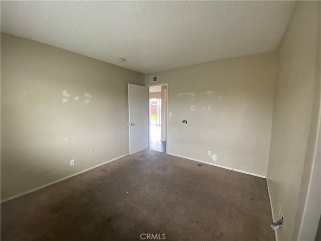 empty room with visible vents, baseboards, and a textured ceiling