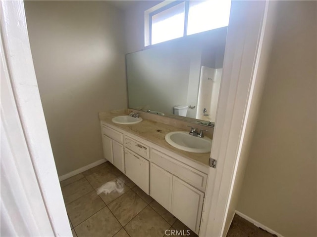 bathroom with double vanity, tile patterned floors, walk in shower, and a sink