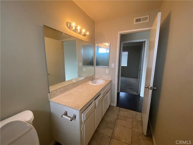 bathroom with tile patterned floors, visible vents, toilet, and vanity