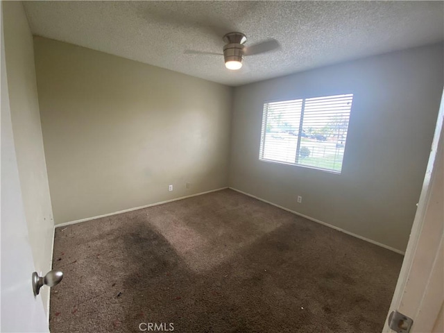 unfurnished room featuring a textured ceiling, baseboards, carpet floors, and ceiling fan