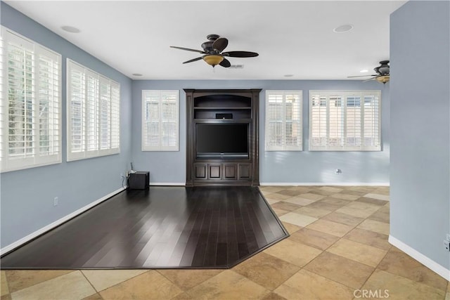 unfurnished living room with baseboards and ceiling fan