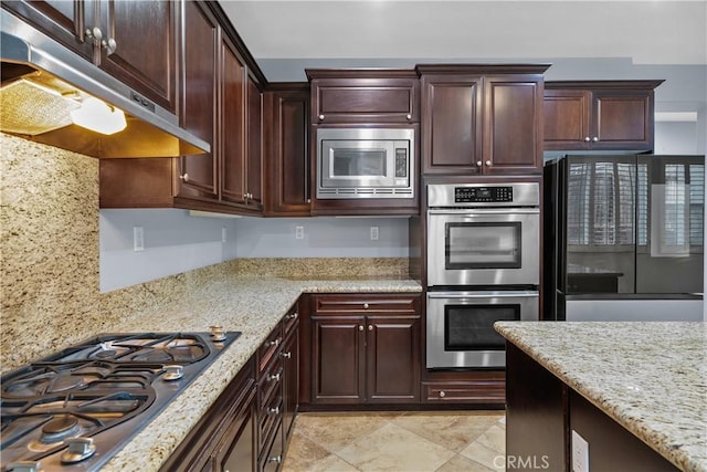 33740 Old Trail Dr, Yucaipa, CA 92399 - kitchen with under cabinet range hood, appliances with stainless steel finishes, light stone countertops, and dark brown cabinetry