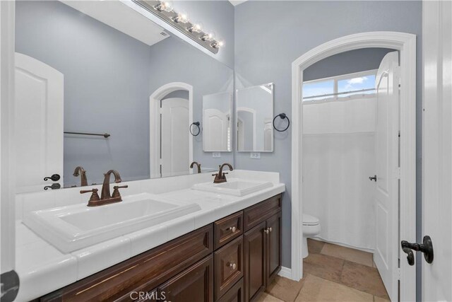 33740 Old Trail Dr, Yucaipa, CA 92399 - full bathroom featuring toilet, double vanity, and a shower with curtain