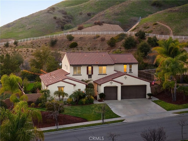 exterior space with fence, a tiled roof, a front yard, stucco siding, and driveway