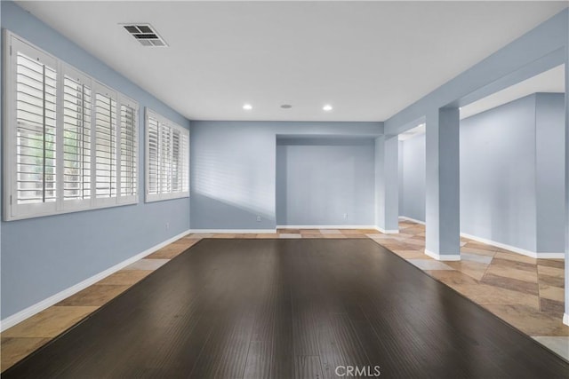 interior space with wood finished floors, recessed lighting, baseboards, and visible vents