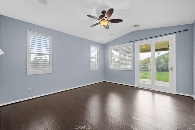 empty room featuring visible vents, ceiling fan, dark wood-type flooring, and a healthy amount of sunlight