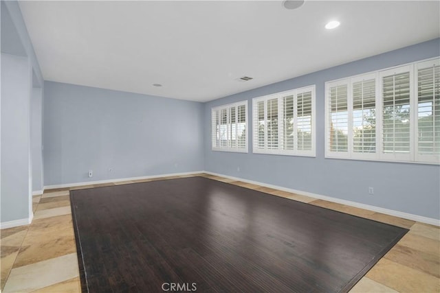 spare room featuring visible vents, recessed lighting, and baseboards