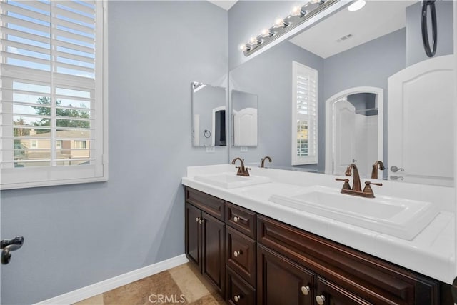 full bathroom with baseboards, visible vents, a shower, and a sink
