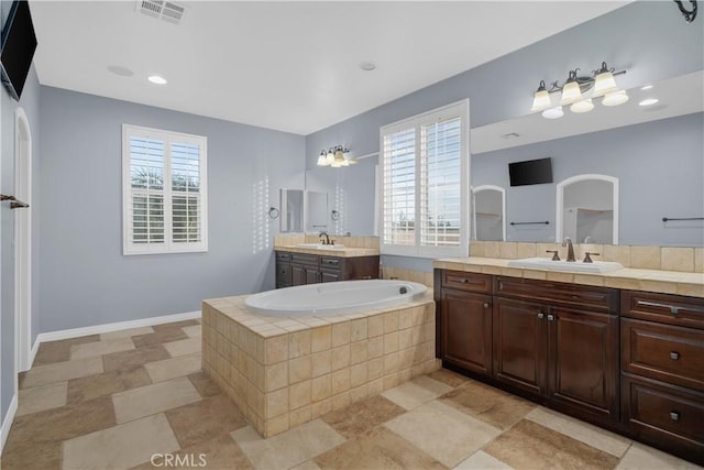 full bathroom featuring a wealth of natural light, visible vents, and a sink