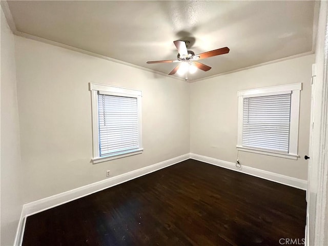 empty room with crown molding, dark wood-style floors, baseboards, and ceiling fan