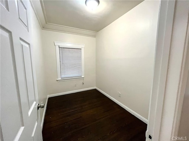 unfurnished room with baseboards and dark wood-style flooring