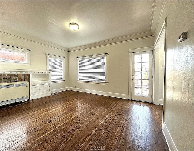 unfurnished living room featuring radiator, baseboards, dark wood-style flooring, and ornamental molding