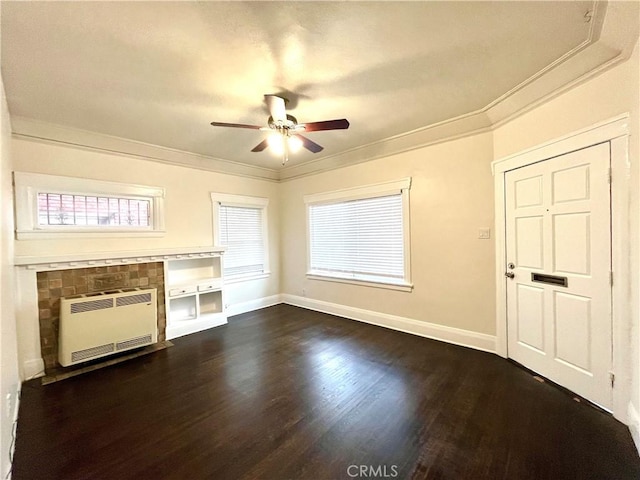 unfurnished living room featuring ceiling fan, heating unit, dark wood-style floors, and crown molding