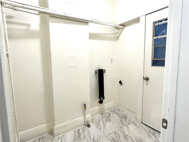 washroom featuring baseboards, marble finish floor, and laundry area