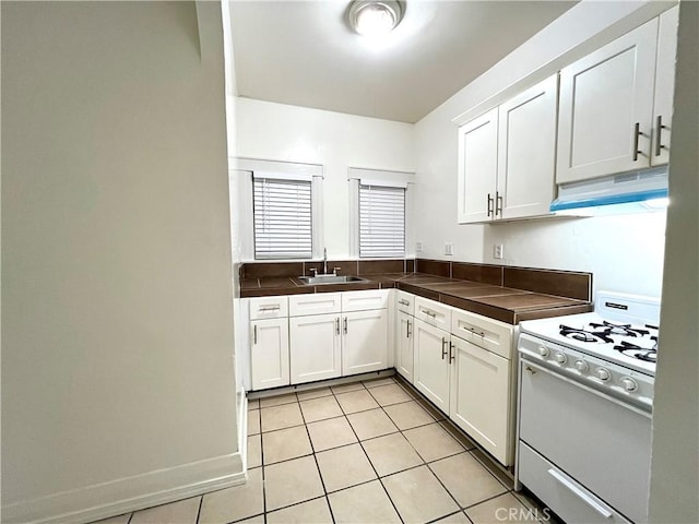 332 W 9th St, Long Beach, CA 90813 - kitchen with light tile patterned floors, under cabinet range hood, white cabinets, white range with gas cooktop, and a sink