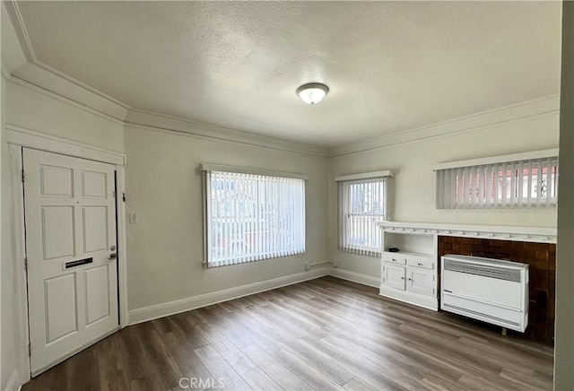 332 W 9th St, Long Beach, CA 90813 - unfurnished living room with a textured ceiling, baseboards, heating unit, ornamental molding, and dark wood finished floors