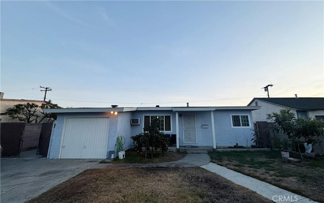 single story home with fence, a wall mounted air conditioner, stucco siding, a garage, and driveway