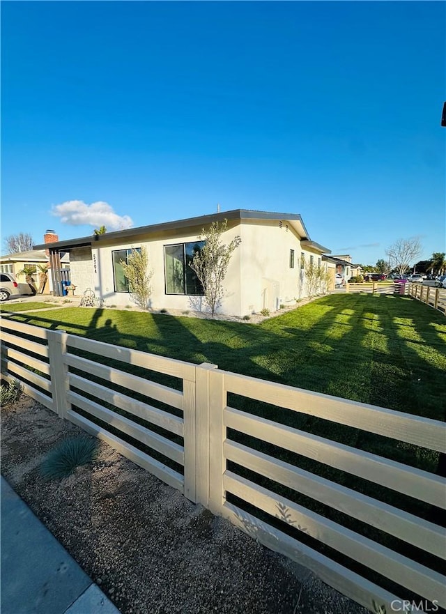 exterior space with a front yard, fence, a residential view, and stucco siding