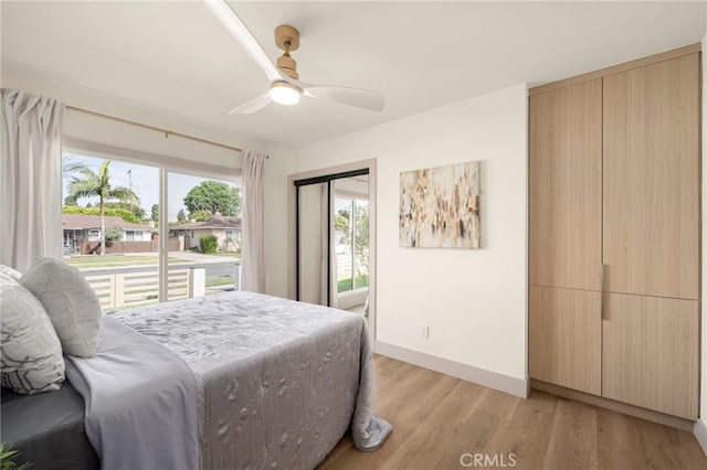 bedroom with a ceiling fan, baseboards, and light wood finished floors