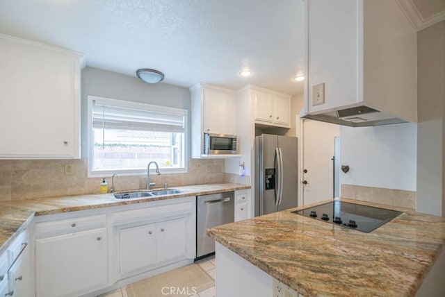 kitchen with a sink, backsplash, white cabinetry, stainless steel appliances, and wall chimney range hood