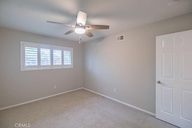 unfurnished room with light carpet, visible vents, ceiling fan, and baseboards