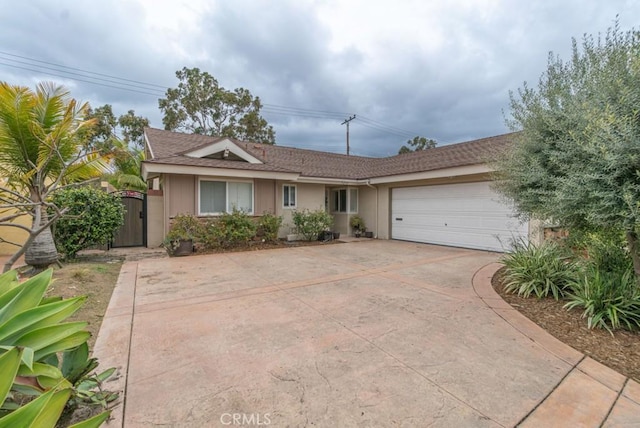 single story home with driveway, a garage, and a gate