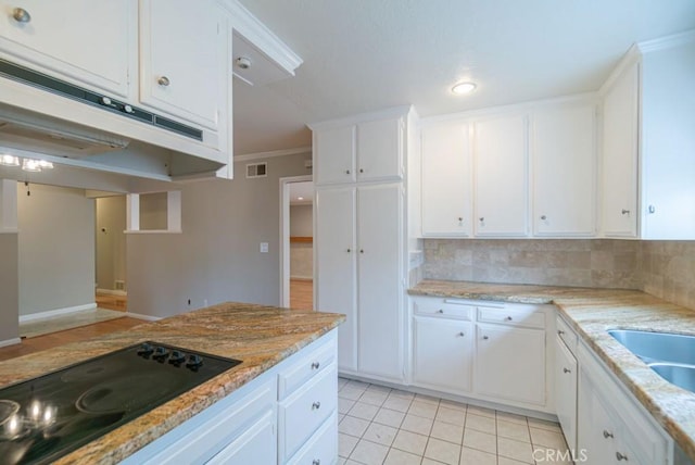 kitchen with crown molding, light tile patterned floors, decorative backsplash, white cabinetry, and black electric cooktop