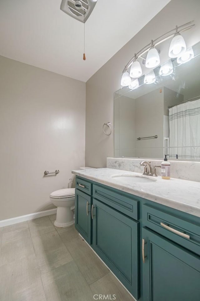 bathroom featuring baseboards, toilet, a shower with shower curtain, tile patterned floors, and vanity