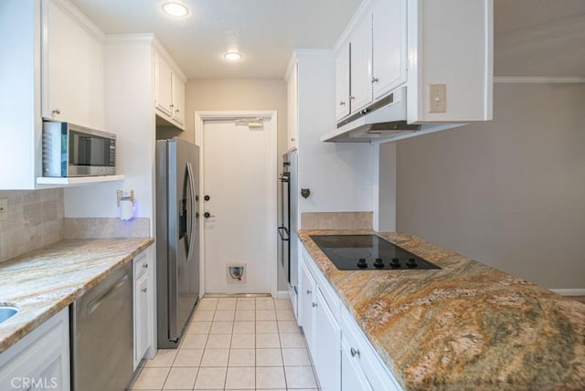 kitchen with under cabinet range hood, appliances with stainless steel finishes, white cabinets, and light tile patterned floors