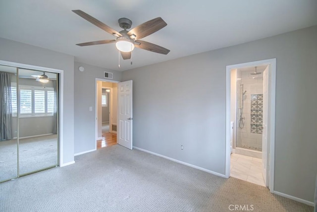 unfurnished bedroom featuring carpet, visible vents, baseboards, ensuite bath, and a closet