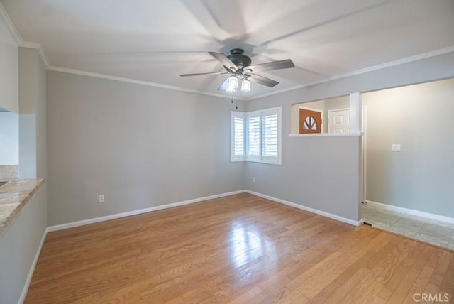 unfurnished room featuring baseboards, a ceiling fan, crown molding, and light wood finished floors