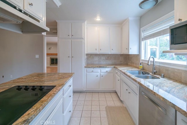 kitchen featuring a sink, under cabinet range hood, stainless steel appliances, light tile patterned floors, and decorative backsplash