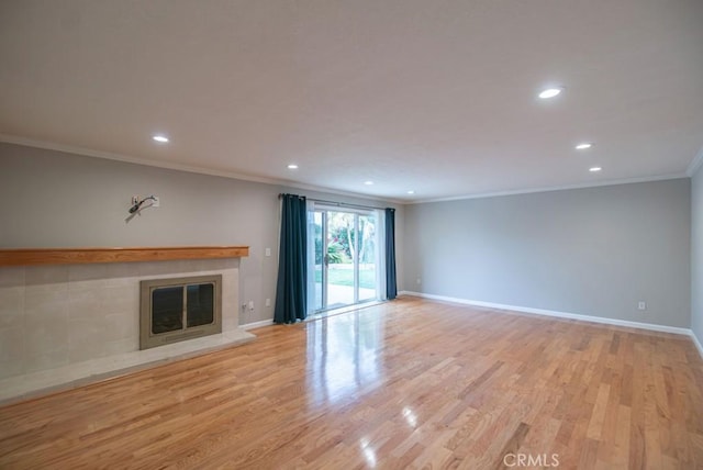 unfurnished living room with baseboards, light wood-type flooring, ornamental molding, recessed lighting, and a fireplace