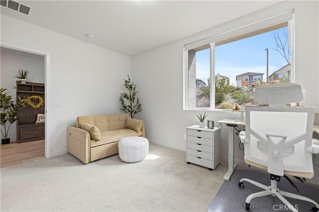 home office featuring light carpet, visible vents, and baseboards
