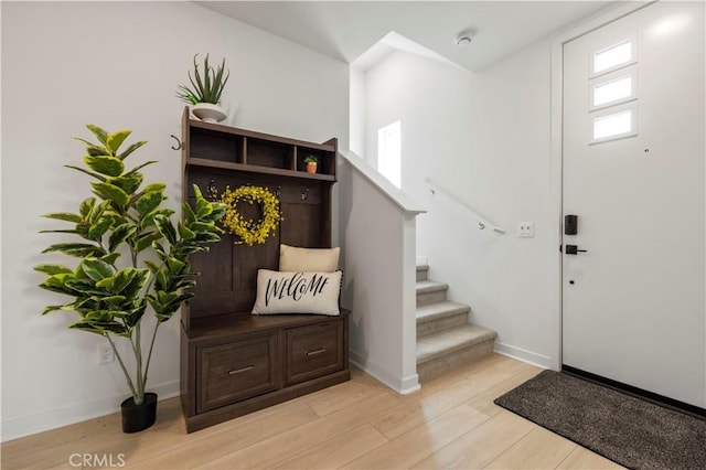 entryway featuring light wood-type flooring, stairway, and baseboards