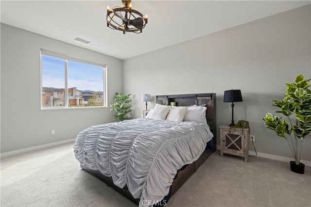 carpeted bedroom with a chandelier, visible vents, and baseboards