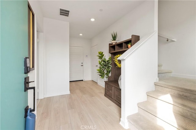 foyer entrance featuring stairway, visible vents, baseboards, light wood-style flooring, and recessed lighting