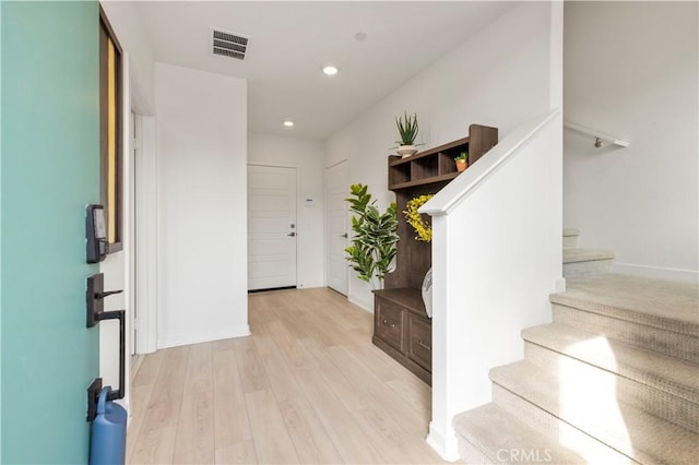 foyer entrance with visible vents, recessed lighting, stairs, light wood finished floors, and baseboards