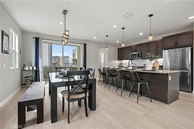 dining area with recessed lighting, light wood-style floors, visible vents, and baseboards