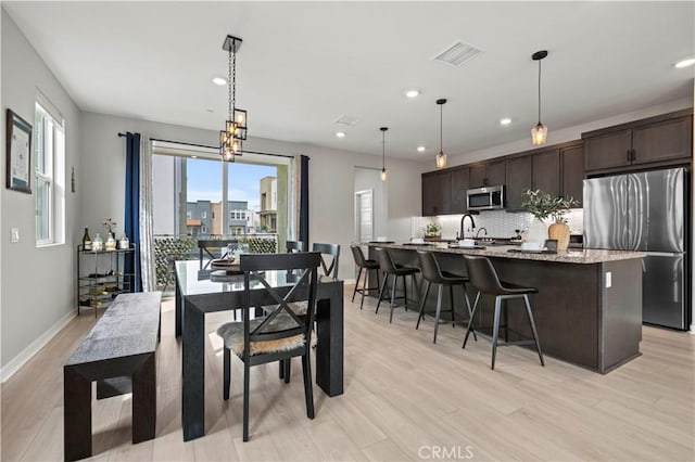 dining room with recessed lighting, visible vents, light wood-type flooring, and baseboards